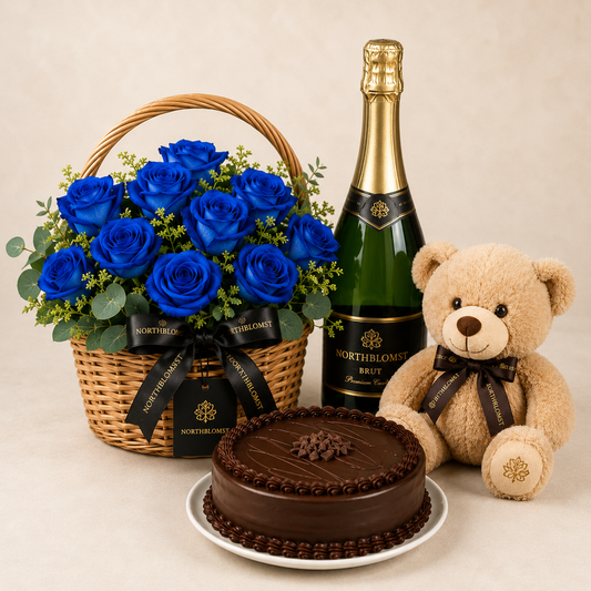 Luksuriøs kurv med blå roser, mousserende gave, chokoladekage og bamse