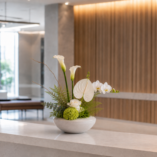 Nordic reception flower arrangement with seasonal flowers, greenery and a minimalist vase for a modern business space in Denmark