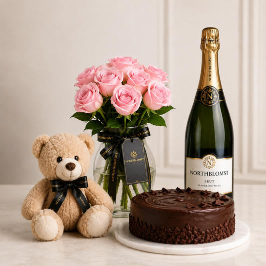 Luksuriøs lyserød rosenbuket med mousserende gave, chokoladekage og bamse